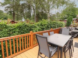 A table and chairs on a deck at Beech Grove Lodge, Glade 17, Fallbarrow Park near Bowness on Windermere