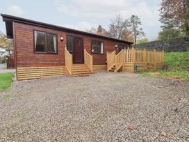 A wooden cabin with steps and a gravel driveway at Robin View Lodge, Beckside 3, Limefitt Park near Windermere