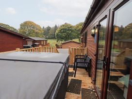An outdoor area with a hot tub and chairs at Robin View Lodge, Beckside 3, Limefitt Park near Windermere