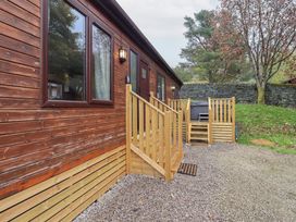 An exterior view of a wooden lodge with steps and gravel area at Robin View Lodge Beckside 3 Limefitt Park near Windermere