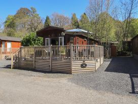 A lodge with a deck and umbrella at Badgers Hollow Lodge Grasmere 30 White Cross Bay near Windermere