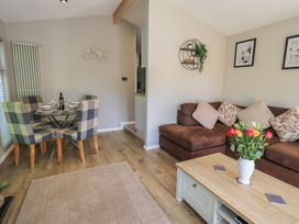 A living room and dining area with a table and couch at Badgers Hollow Lodge Grasmere 30, White Cross Bay near Windermere