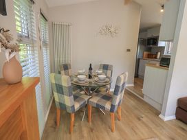 A dining room with a table and chairs at Badgers Hollow Lodge Grasmere 30 White Cross Bay near Windermere