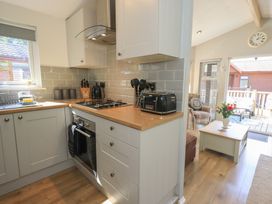 A kitchen with a stove and toaster at Badgers Hollow Lodge Grasmere 30, White Cross Bay near Windermere