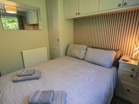 A bedroom with a bed and pillows at Badgers Hollow Lodge Grasmere 30, White Cross Bay near Windermere