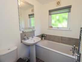A bathroom with a tub and sink at Badgers Hollow Lodge Grasmere 30 White Cross Bay near Windermere