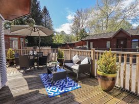 A patio area with table and chairs at Badgers Hollow Lodge in Grasmere 30, White Cross Bay near Windermere
