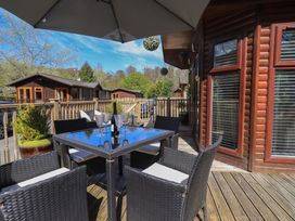 An outdoor seating area with a table and chairs at Badgers Hollow Lodge Grasmere 30, White Cross Bay near Windermere