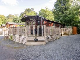 An outdoor space with a wooden lodge and decking at Badgers Hollow Lodge, Grasmere 30, White Cross Bay near Windermere