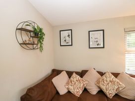 A living room with a sofa and wall art at Badgers Hollow Lodge in Grasmere 30, White Cross Bay near Windermere