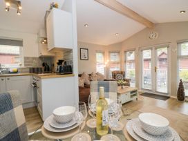 A kitchen and dining area with utensils and a couch at Badgers Hollow Lodge Grasmere 30 White Cross Bay near Windermere