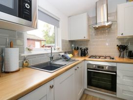 A kitchen with sink, gas stovetop, oven and microwave at Badgers Hollow Lodge, Grasmere 30, White Cross Bay near Windermere