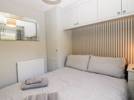 A bedroom with a bed and towels at Badgers Hollow Lodge Grasmere 30 White Cross Bay near Windermere