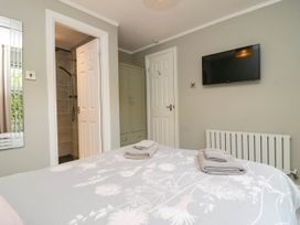 A bedroom with a bed and television at Badgers Hollow Lodge Grasmere 30 White Cross Bay near Windermere