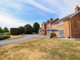 A house with a patio umbrella and garden area at Bodaioch Hall Trefeglwys near Caersws