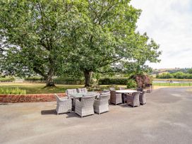An outdoor seating area with a table and chairs at Bodaioch Hall Trefeglwys near Caersws