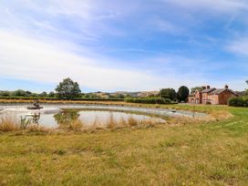 A house next to a pond and grassy area at Bodaioch Hall Trefeglwys near Caersws
