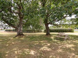 A garden with trees and a picnic table at Bodaioch Hall Trefeglwys near Caersws