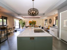 A kitchen with an island and bar stools at Thornbury, Barnard's Green, Malvern