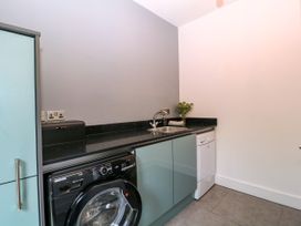 A laundry room with a washing machine and sink at Thornbury in Barnard's Green, Malvern