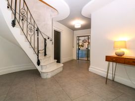 A hallway with a staircase and lamp at Thornbury, Barnard's Green, Malvern