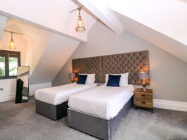A bedroom with two beds and a lamp at Thornbury, Barnard's Green, Malvern