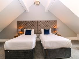 A bedroom with two single beds and bedside tables at Thornbury, Barnard's Green, Malvern
