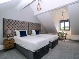 A bedroom with two single beds and a chair at Thornbury in Barnard's Green, Malvern