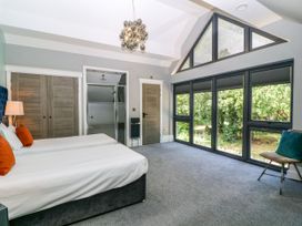 A bedroom with twin beds and large windows at Thornbury, Barnard's Green, Malvern