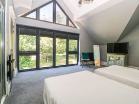 A bedroom with two beds and large windows at Thornbury in Barnard's Green, Malvern