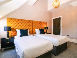 A bedroom with twin beds and a decorative headboard at Thornbury in Barnard's Green, Malvern