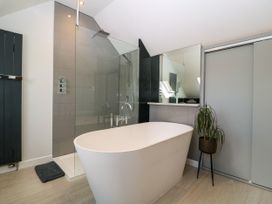 A bathroom with a bathtub and shower at Thornbury, Barnard's Green, Malvern