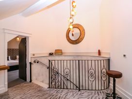 A hallway with a railing and a bar stool at Thornbury, Barnard's Green, Malvern