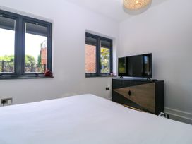 A bedroom with a television and windows at Thornbury in Barnard's Green, Malvern