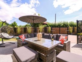 A garden with seating area and umbrella at Thornbury in Barnard's Green, Malvern