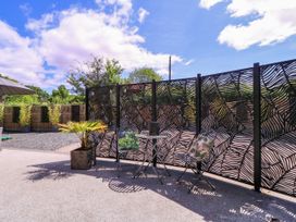 A garden with a table and chairs by a decorative fence at Thornbury, Barnard's Green, Malvern