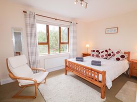 A bedroom with a bed and a chair at Ard na Gréine in Glenties, County Donegal