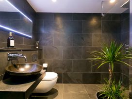 A bathroom with a toilet, vanity sink, and plant at Scilly Stack in Penzance