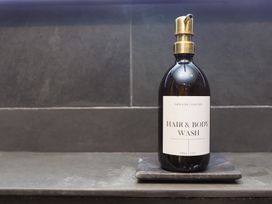 A hair and body wash bottle on a slate tray at Scilly Stack in Penzance