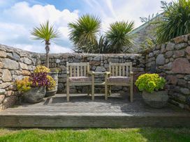 A garden with chairs on a wooden deck at Scilly Stack in Penzance