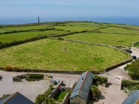 An outdoor view with grassy fields and stone walls at Scilly Stack in Penzance