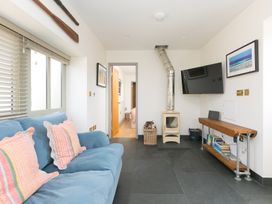 A living room with a sofa and television at Scilly Stack in St Just
