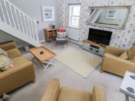 A living room with a sofa and television at Crown Cottage in Penally