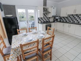 A kitchen with table and chairs at Crown Cottage in Penally