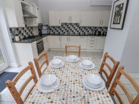 A kitchen with a dining table set and appliances at Crown Cottage in Penally