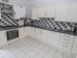 A kitchen with cabinets and an oven at Crown Cottage Penally
