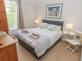 A bedroom with a bed and two lamps at Crown Cottage in Penally