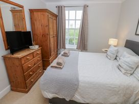 A bedroom with a bed and television at Crown Cottage Penally