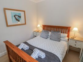A bedroom with a bed and bedside tables at Crown Cottage in Penally