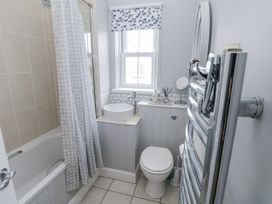 A bathroom with a bathtub and sink at Crown Cottage Penally